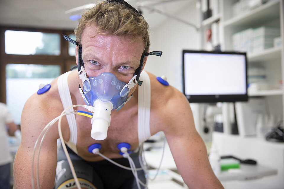Mann auf einem Fahrrad mit Maske zur Sauerstoffmessung während der Leistungsdiagnostik